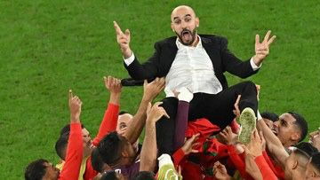 Para pemain Maroko mengusung sang pelatihnya Walid Reragui setelah menenggelamkan Spanyol. (Getty Images)
