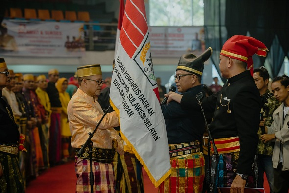 Adam Sinte menerima bendera KKSS dari Ketua BPW KKSS Kaltim H Alimuddin Latief