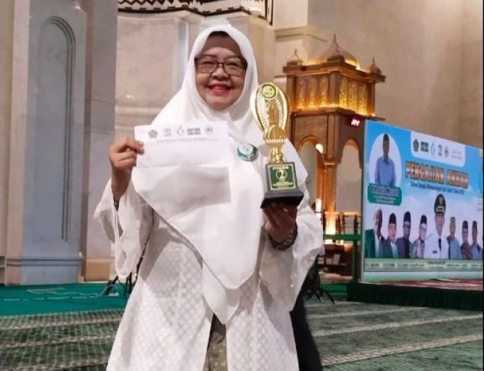 Ketua LKK NU Balikpapan Bunda Arita menerima piala ke-2 mobil hias